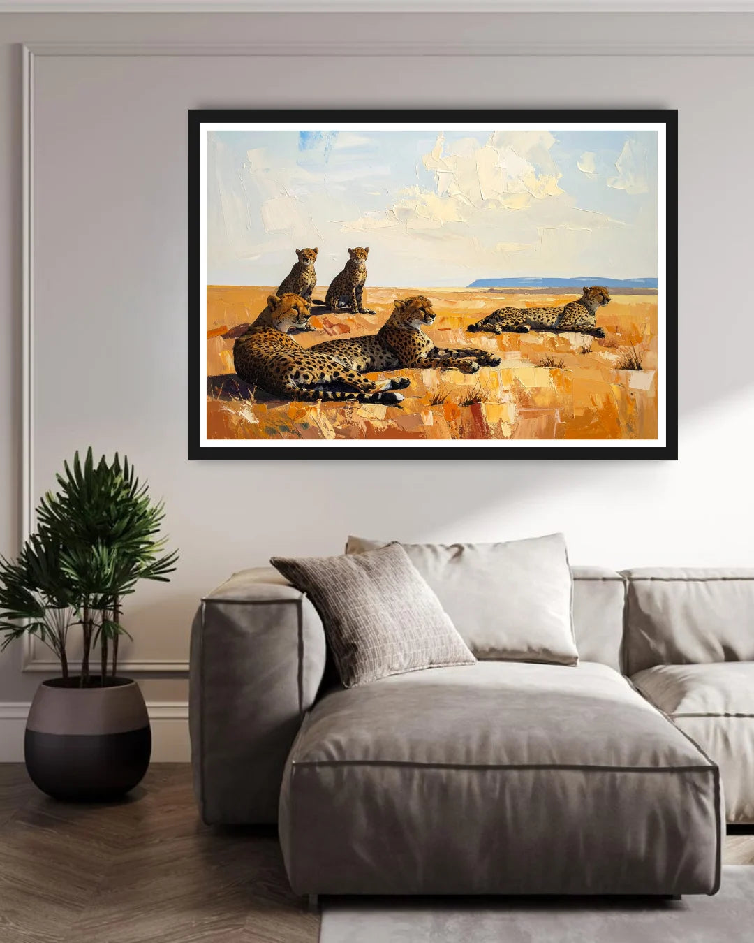 Framed painting of leopards on a wall above a sofa in a living room.