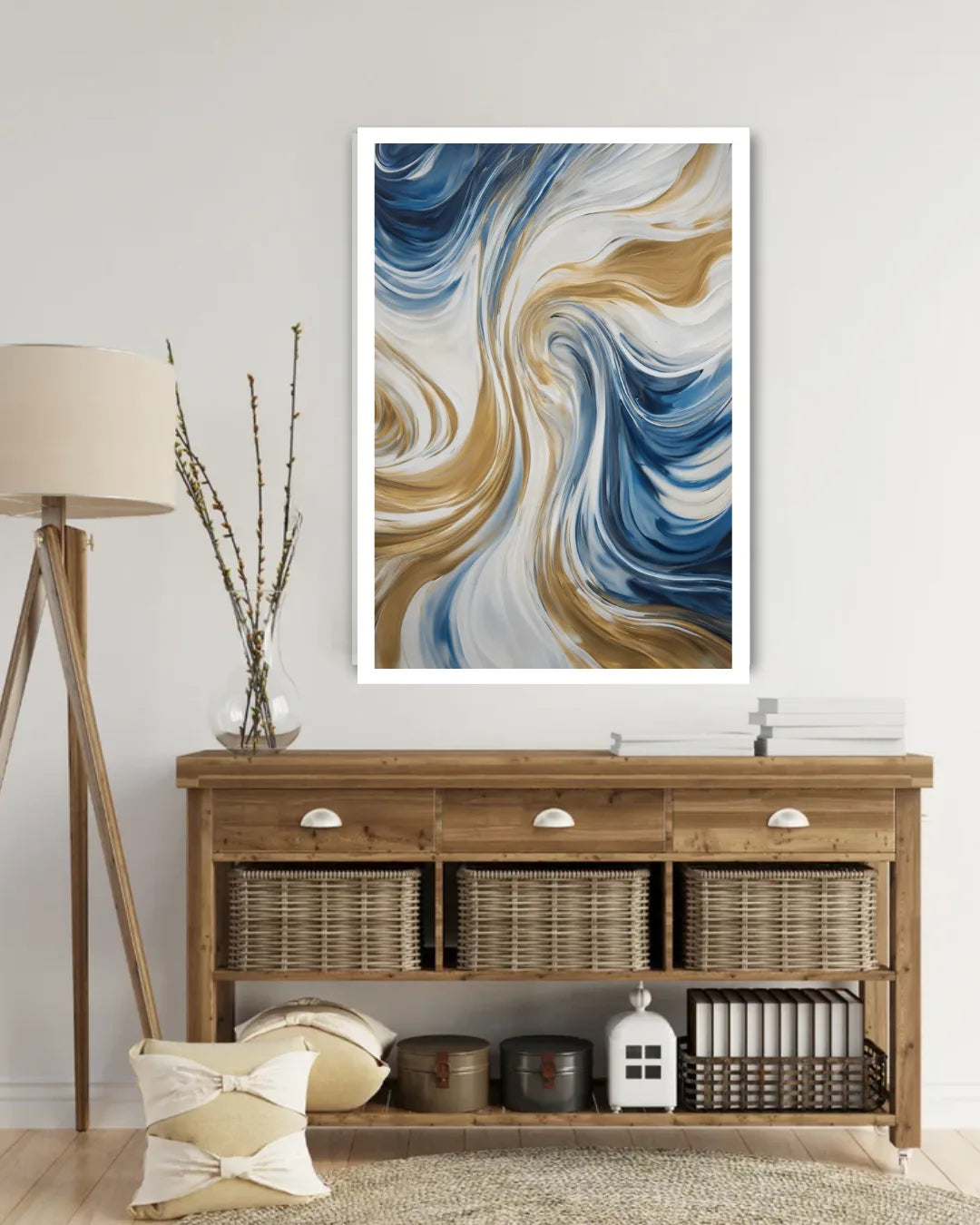 A framed abstract wall art print with swirling blue, white, and tan brushstrokes, displayed above a wooden console table in a styled room setting.