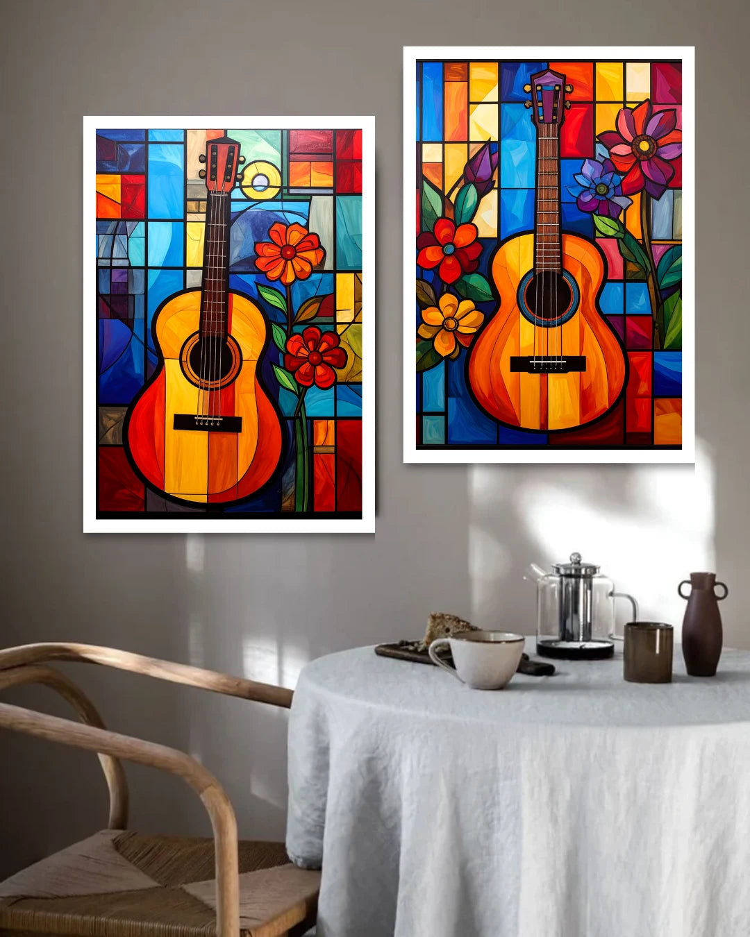 Two colorful framed artworks of guitars on a wall above a dining table.