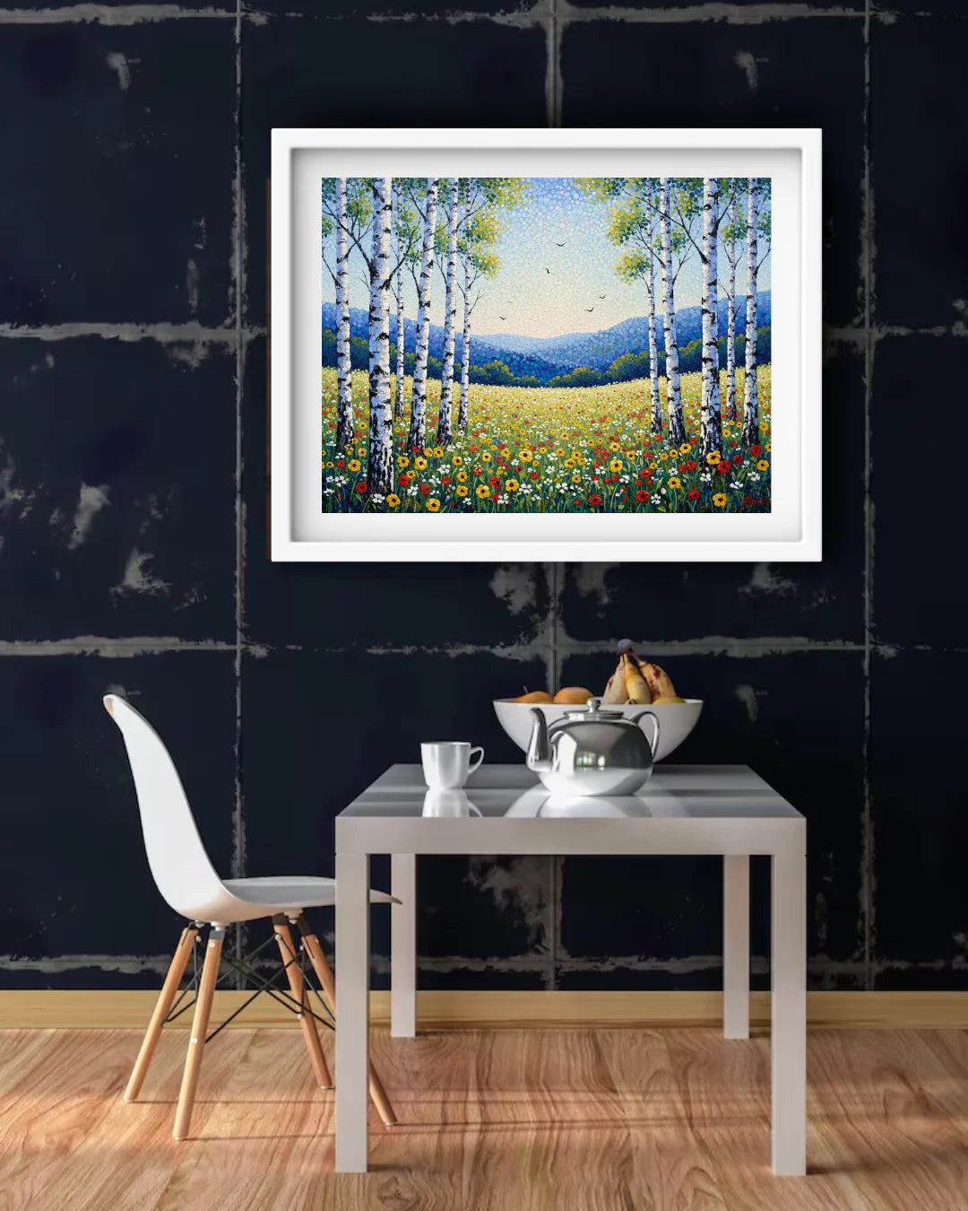 Framed painting of a landscape with trees and flowers above a dining table.