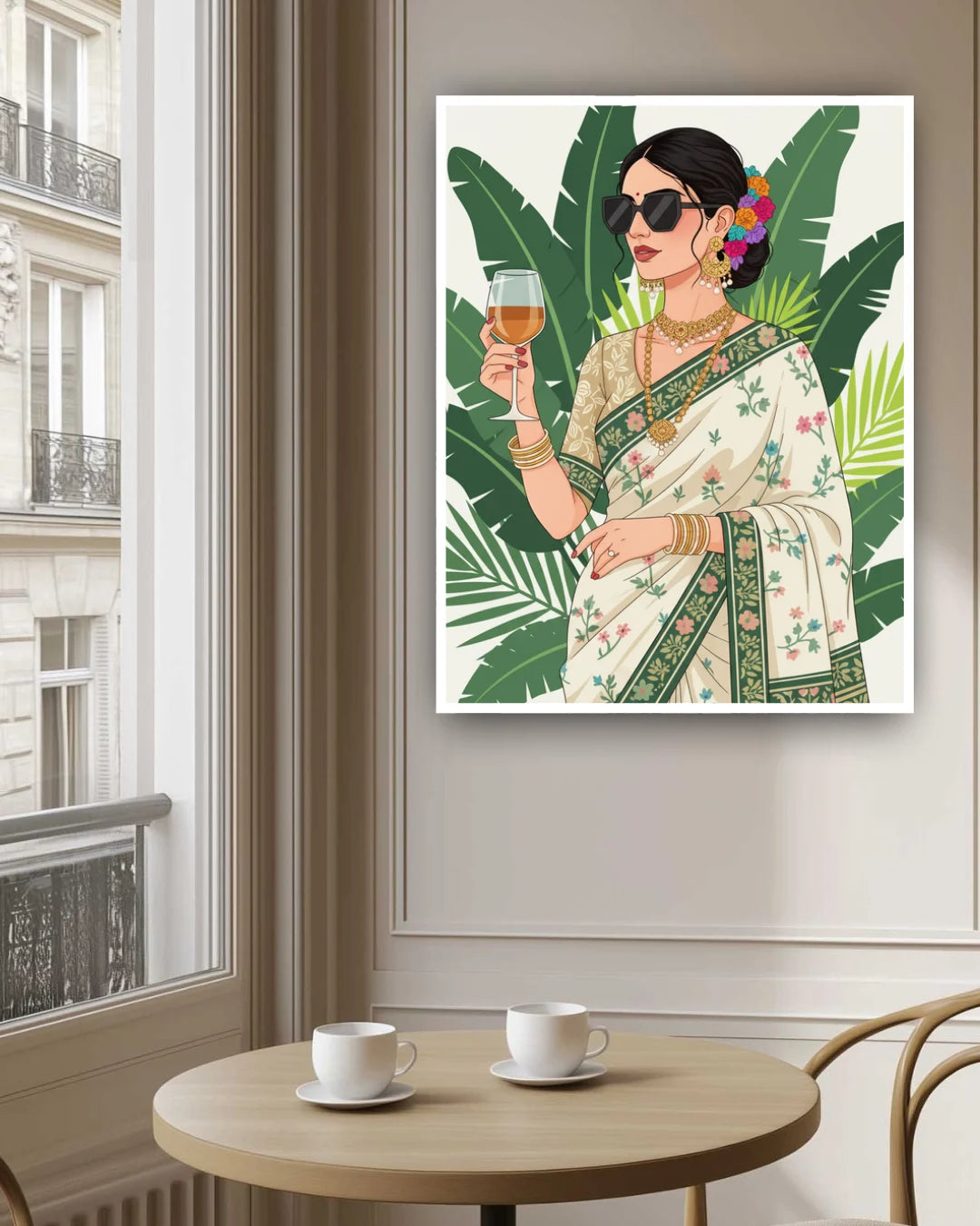 Framed artwork of a woman in a saree holding a glass of wine, placed above a table with two cups.