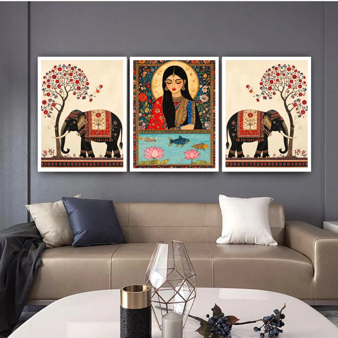 Three framed artworks on a wall above a sofa with decorative elements.