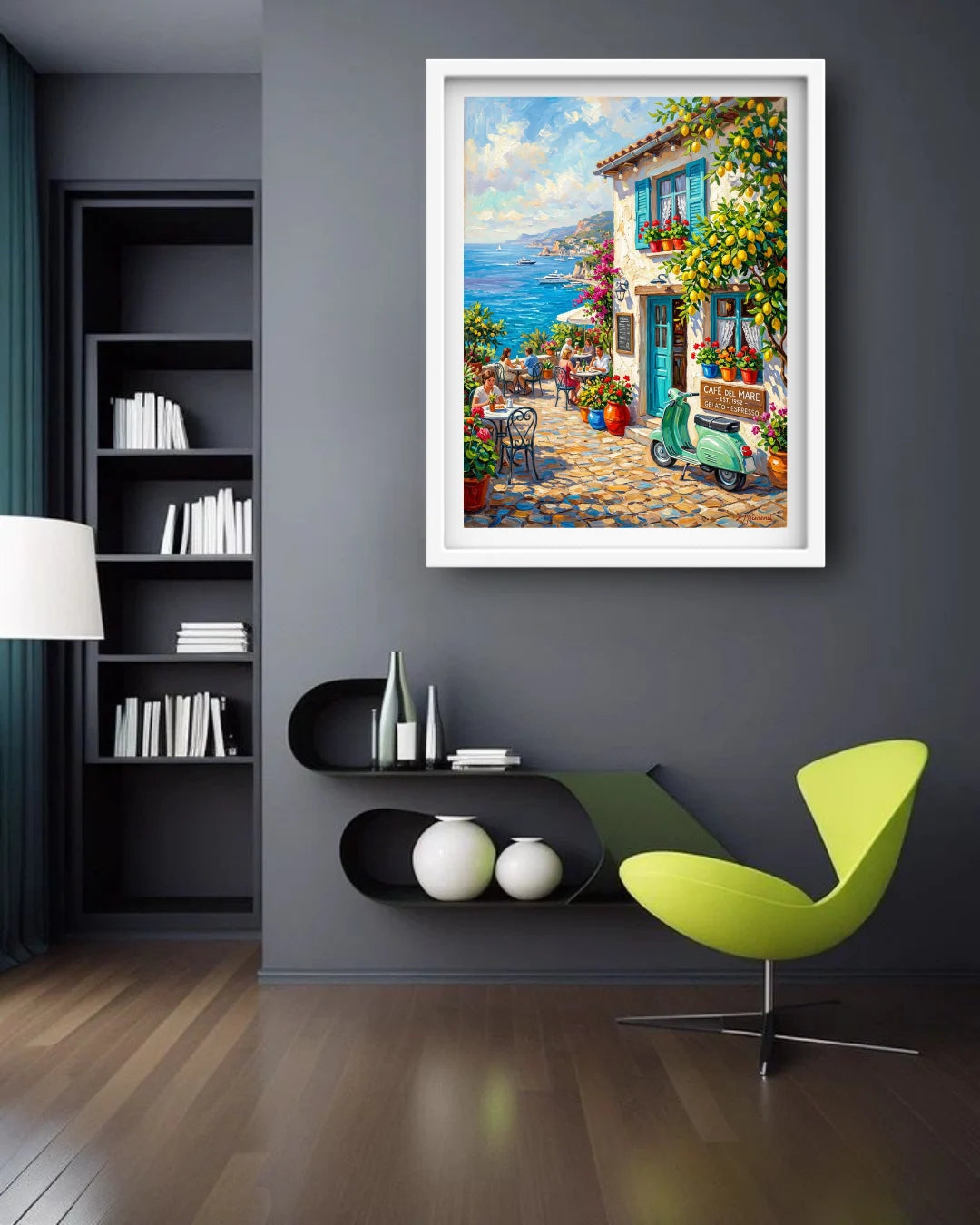 A framed colorful painting of a Mediterranean village street with a green scooter and blue sea in the background, displayed on a dark gray wall in a modern living room setting.