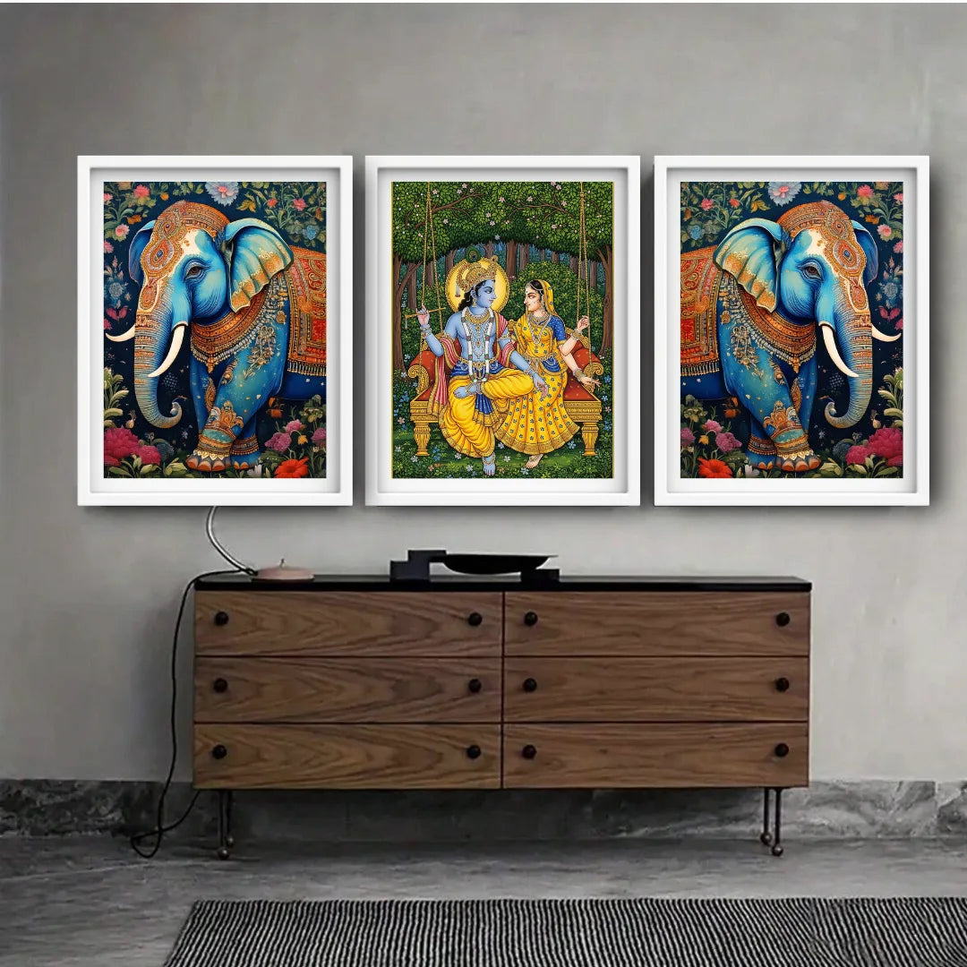 Three framed artworks of elephants and a couple on a wall above a wooden cabinet.