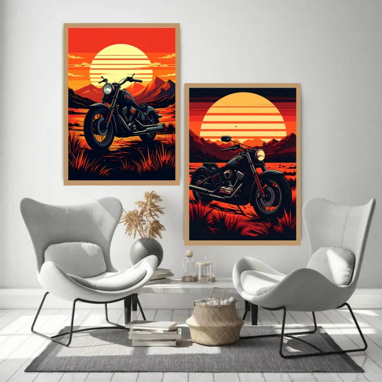 Two framed vertical art prints featuring retro motorcycles against a sunset landscape, displayed on a light gray wall above two modern white chairs in a styled living room.