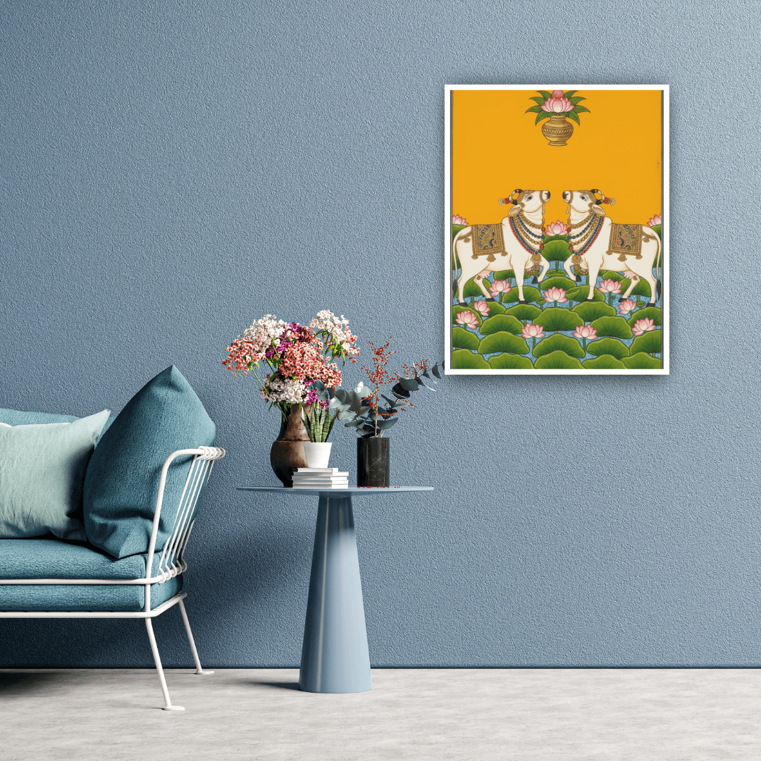 Living room with a blue sofa, small table with flowers, and a framed artwork of two cows on a yellow background.
