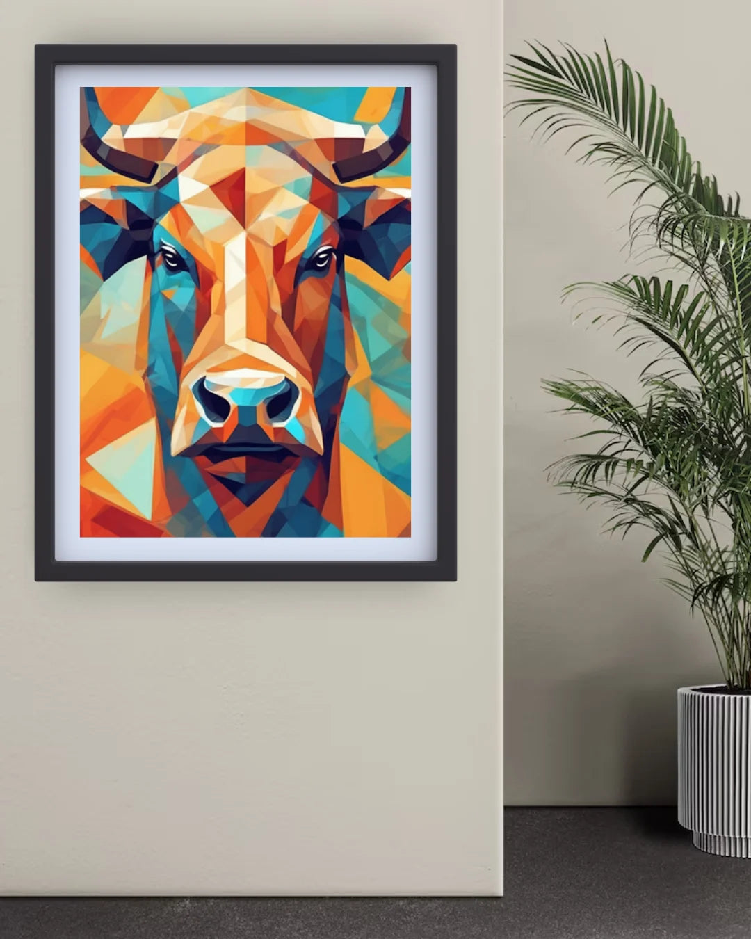 Framed colorful abstract bull art on a wall with a plant beside it.
