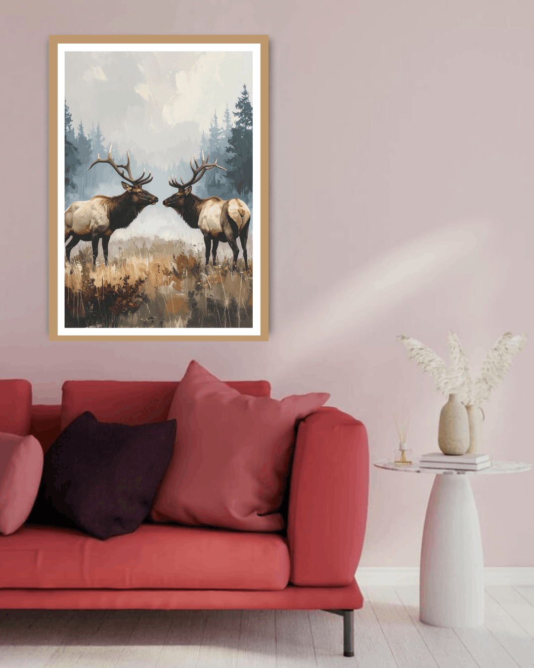 Framed artwork of two elk in a forest scene above a red sofa with pink and black cushions.