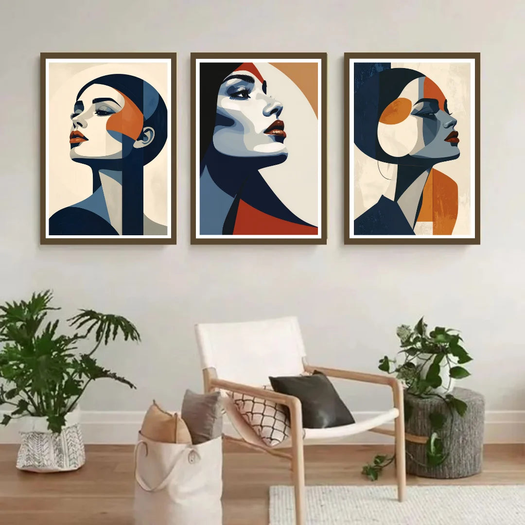 Three abstract art prints of faces on a wall above a chair with plants.