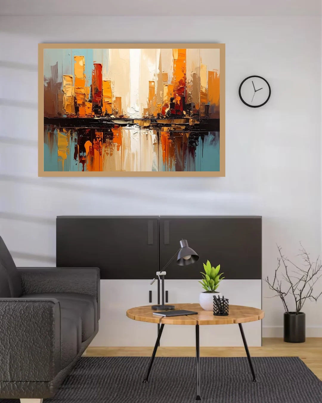 A framed abstract cityscape painting with orange, yellow, black, and blue tones hangs on a white wall above a dark cabinet in a modern living room setting.