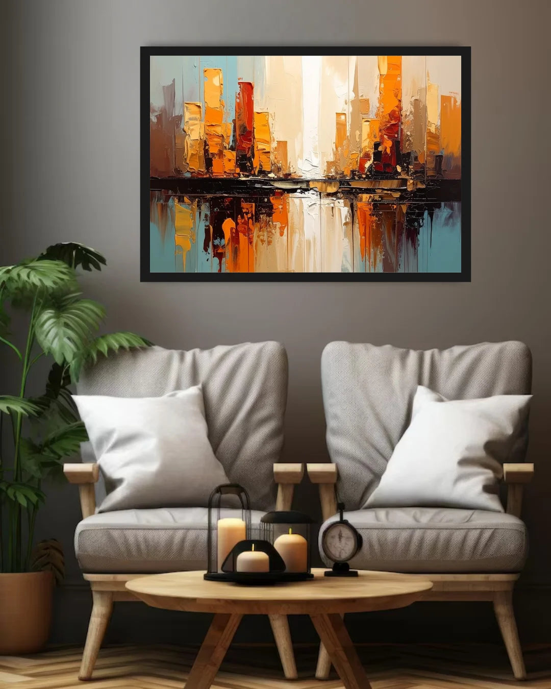 A framed abstract cityscape painting in warm orange, gold, and blue tones hangs on a dark gray wall above two light gray upholstered armchairs with white pillows and a small round wooden coffee table in a styled living room 1