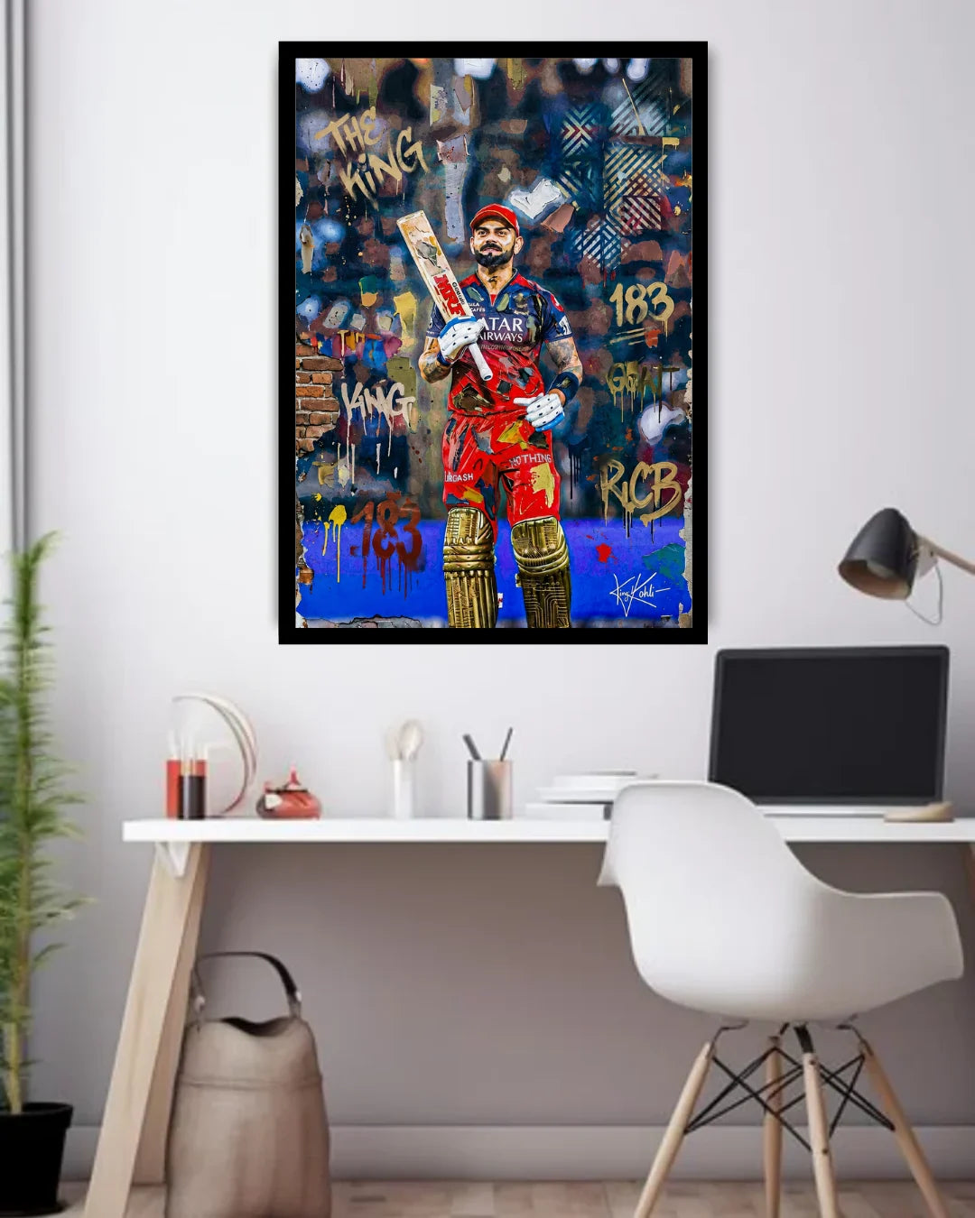 Framed artwork of a sports figure holding a bat on a wall above a desk.
