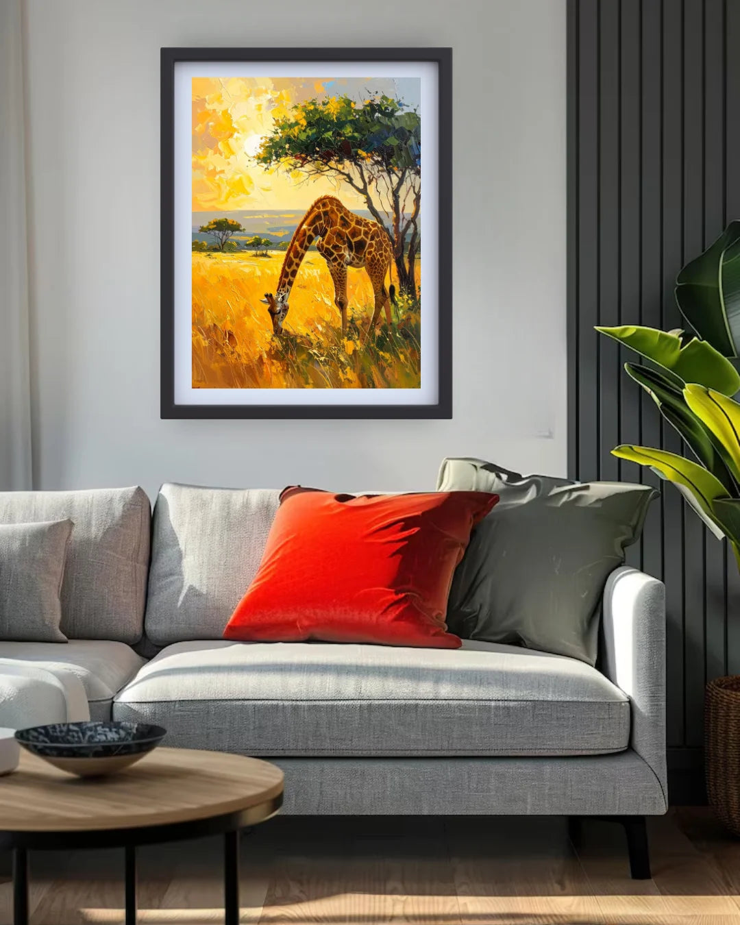 Living room with a gray sofa, red pillow, and framed painting of a giraffe in a field.