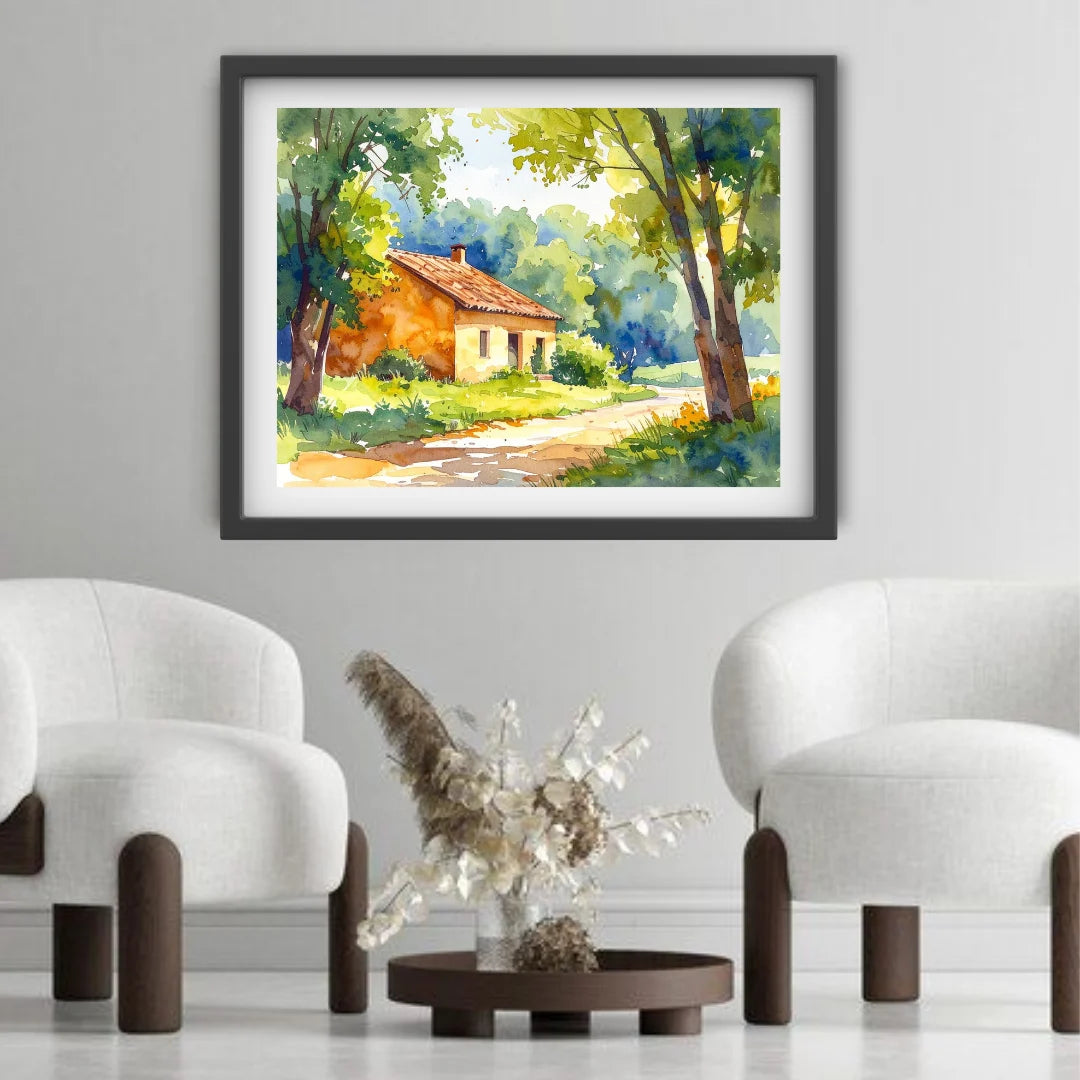 Framed painting of a landscape with a house in a room with white chairs and a small table.