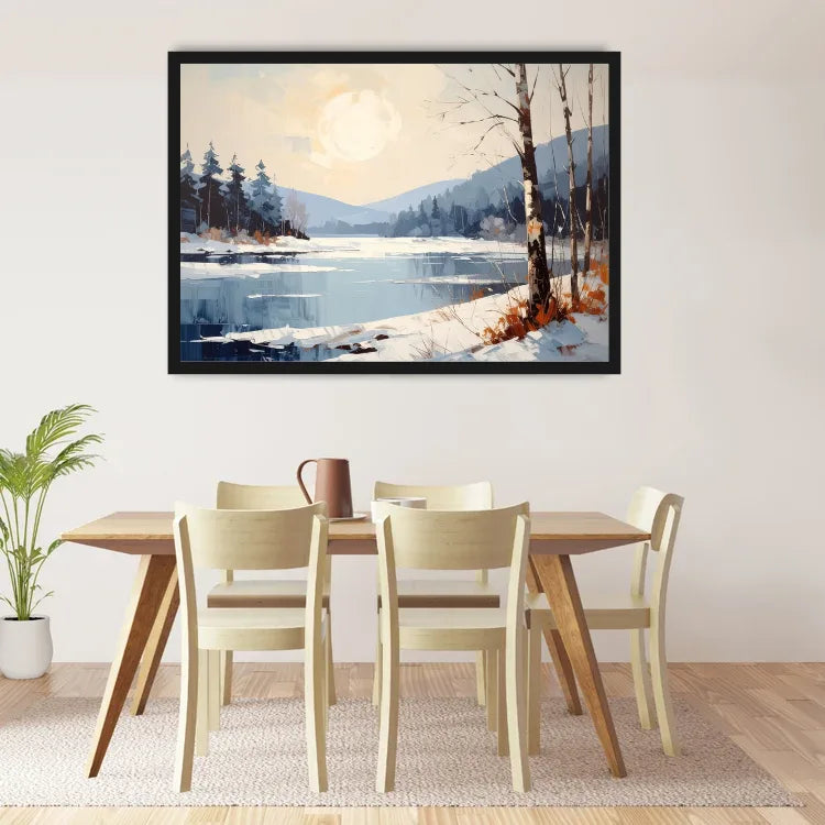 A framed landscape art print depicting a snowy mountain lake scene with a full moon, hung on a light beige wall above a wooden dining table and chairs.
