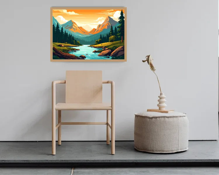 A framed landscape art print depicting a mountain valley with a river, displayed on a light gray wall above a minimalist light wood chair and a round beige pouf with a decorative sculpture.