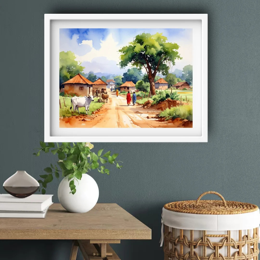 Framed landscape painting of a village scene on a wall above a table with decor items.