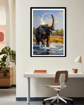 Framed painting of an elephant in a natural setting above a desk.