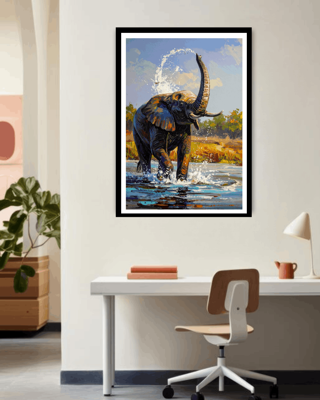 Framed painting of an elephant in a natural setting above a desk.