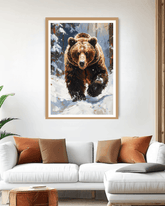 Framed artwork of a bear in a snowy landscape above a white sofa with brown and orange cushions.