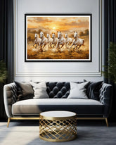 Framed artwork of horses running in a field above a sofa with decorative pillows.