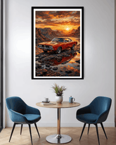Framed artwork of a red car at sunset over water in a modern room with blue chairs and a small table.
