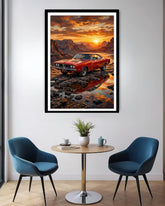 Framed artwork of a red car at sunset over water in a modern room with blue chairs and a small table.