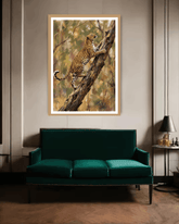 Framed artwork of a leopard on a branch above a green sofa in a room.