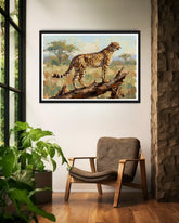 Framed artwork of a cheetah on a branch in a room with a chair and plants.