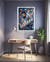 Framed artwork of a sports figure on a wall above a desk in a room with a plant and lamp.