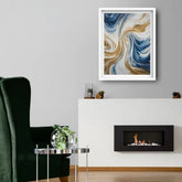 A framed abstract art print with swirling blue, gold, and white patterns, displayed on a light gray wall above a white fireplace mantel in a modern living room setting.