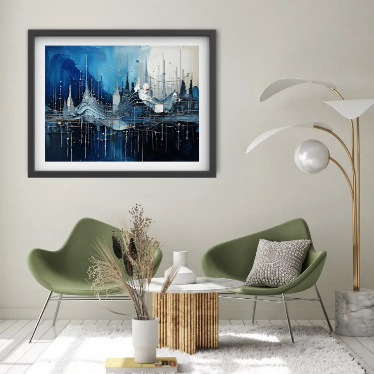 A framed abstract blue and white painting hangs on a light beige wall above two green lounge chairs in a modern living room setting.