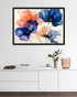 A framed art print depicting a pink flamingo in a tropical pond with lily pads and a reflection, displayed on a gray wall above a dining table setting with chairs and small tables.