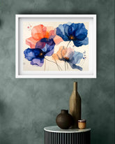 A framed wall art print depicting a pink flamingo standing in a tropical pond with lily pads and trees, displayed above a sofa with neutral-toned pillows in a living room setting.