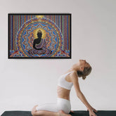 A woman in white activewear poses on a yoga mat in a studio, with a large framed colorful Buddha mandala print hanging on the wall above her.
