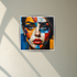 Colorful abstract face painting framed on a wall with natural light across the surface.