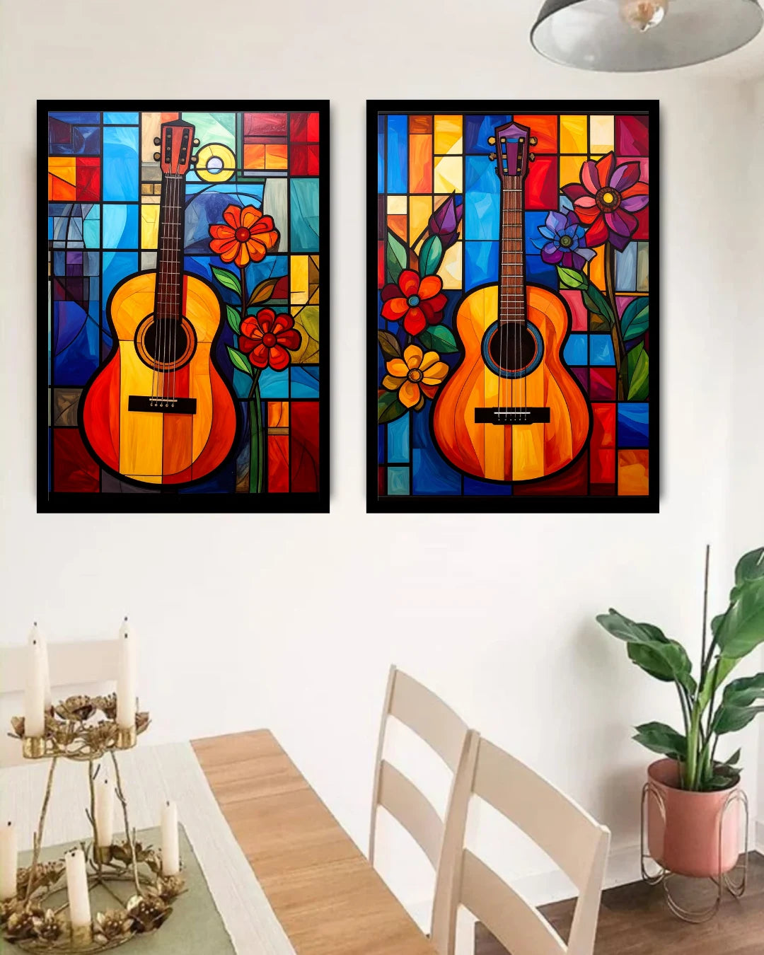 Two colorful framed artworks of guitars with flowers on a wall above a dining table.