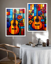 Two colorful framed artworks of guitars on a wall above a dining table.