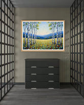 Framed landscape painting above a black dresser in a room with geometric wall patterns.