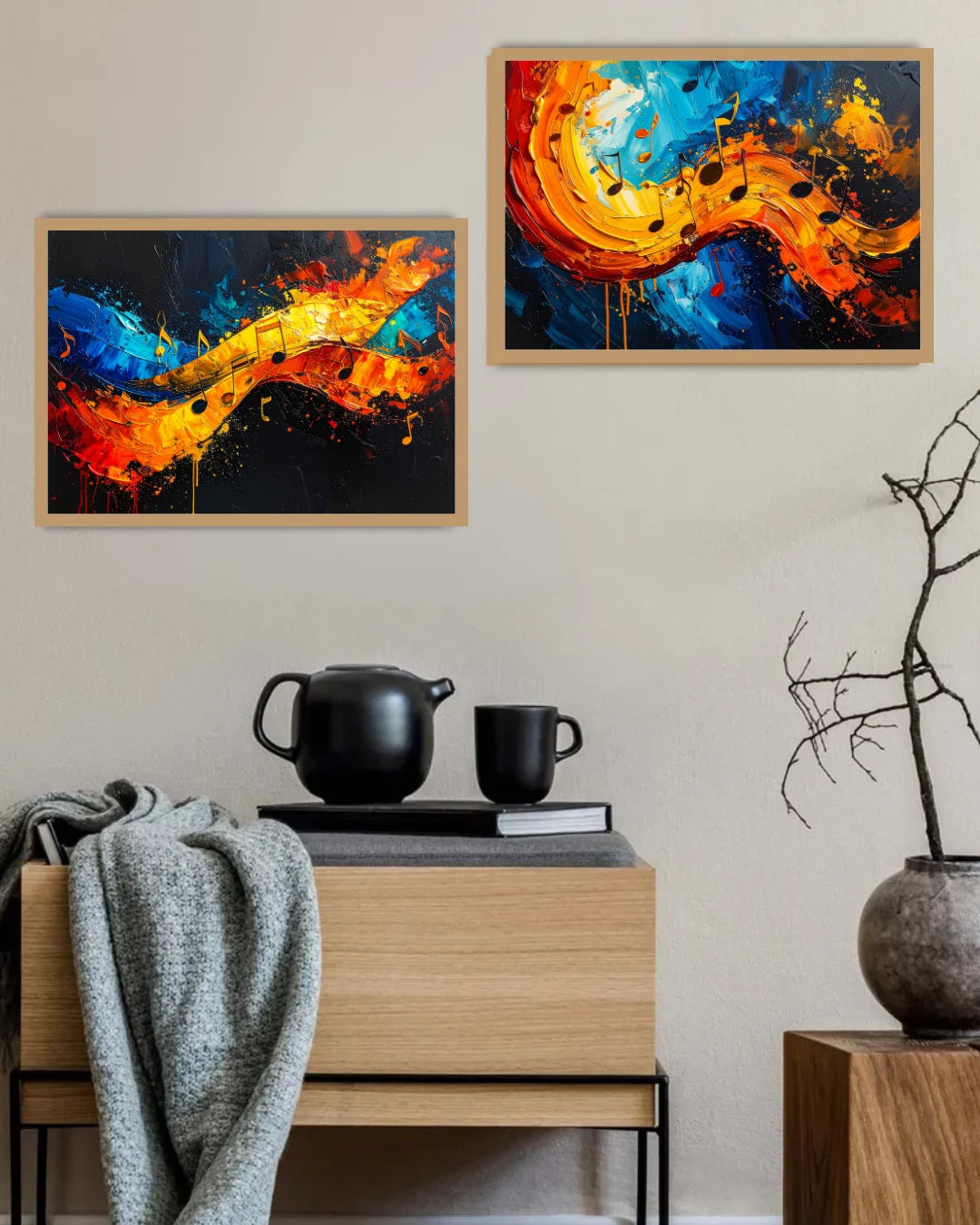 Two abstract paintings on a wall above a wooden cabinet with a teapot and cups.