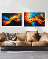 Two abstract paintings above a brown sofa with decorative pillows and a blanket.