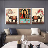 Three framed artworks on a wall above a sofa with decorative elements.