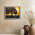 Framed artwork of a tree with a sunset background on a wall above decorative vases.