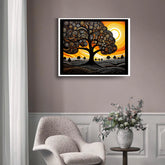 Framed abstract artwork of a tree with a sunset on a wall above a chair and table with a vase.