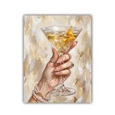 A vertical art print or poster depicting a hand holding a martini glass with a gold-leaf garnish, rendered in a warm beige, gold, and cream painterly style.