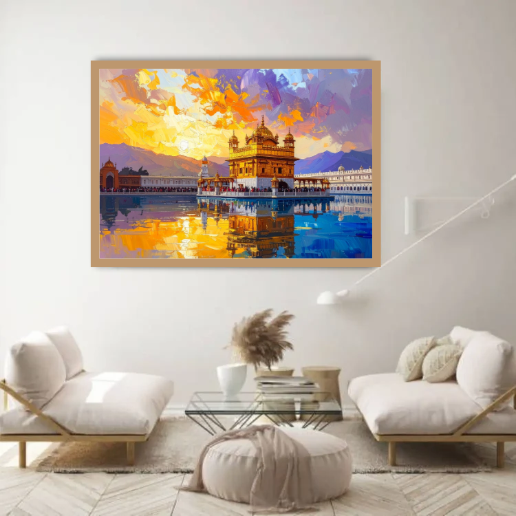 A framed colorful painting of the Golden Temple in Amritsar, displayed on a white wall in a modern living room setting with two white armchairs and a glass coffee table.