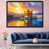 A framed art print depicting the Golden Temple in Amritsar, shown hanging on a pink wall above a blue sofa in a modern living room setting.