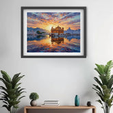 A framed art print depicting the Golden Temple in Amritsar at sunset, hung on a white wall above a wooden console table with plants and decorative vases.