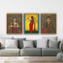 Three framed artworks of women in traditional attire on a wall above a gray sofa.