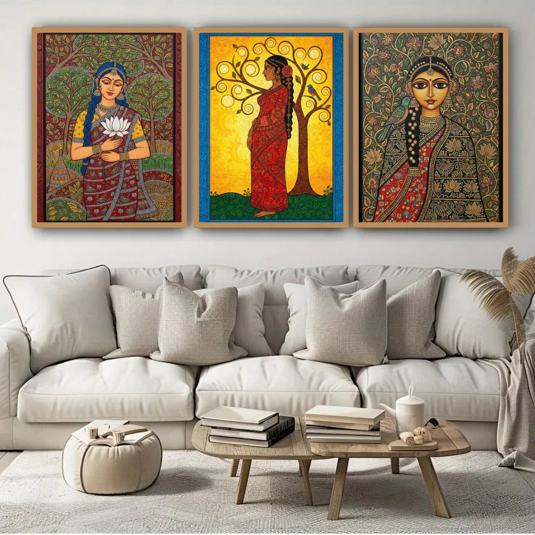 Three colorful paintings of women in traditional attire on a wall above a beige sofa.